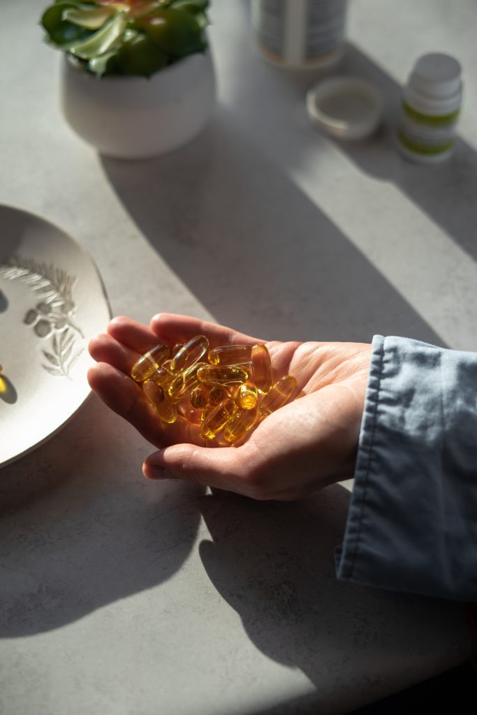 hand holding omega-3 supplements